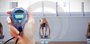 Composite image of close up of woman is holding a stopwatch on a white background