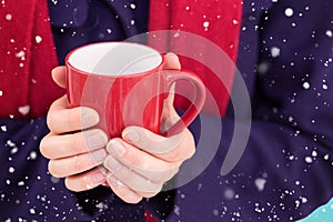 Composite image of close up of a woman in warm clothing holding mug