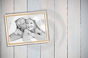 Composite image of closeup of mature man kissing womans cheek in bed