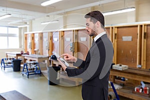 Composite image of concentrated businessman touching his tablet