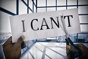 Composite image of conceptual image of businessman cutting paper that reads we cant