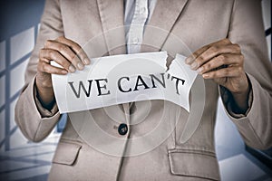 Composite image of conceptual image of businesswoman tearing paper that reads we cant