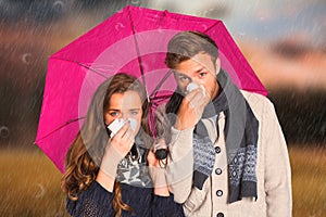 Composite image of couple blowing nose while holding umbrella