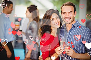 Composite image of couple drinking champagne and valentines hearts 3d