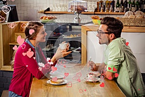 Composite image of couple drinking coffee and valentines hearts 3d