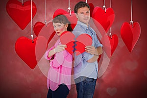 Composite image of couple holding a broken heart 3d