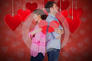 Composite image of couple holding a broken heart 3d