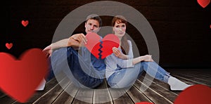 Composite image of couple holding a broken heart