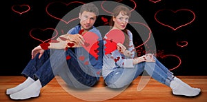 Composite image of couple holding a broken heart