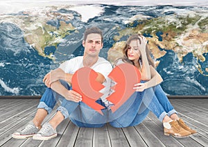 Composite image of couple holding a broken heart