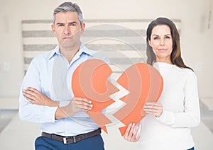 Composite image of couple holding broken heart