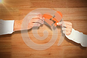 Composite image of couple holding broken heart shape paper