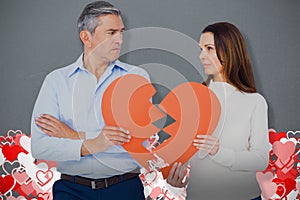 Composite image of couple holding broken heart shape paper