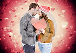 Composite image of couple holding a heart