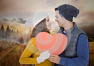 Composite image of couple holding pink heart