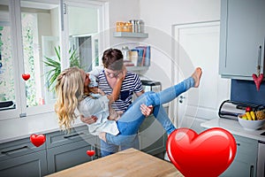 Composite image of couple in kitchen and valentines hearts 3d