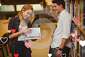 Composite image of couple in library and valentines hearts 3d