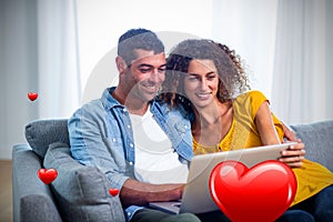 Composite image of couple on sofa and valentines hearts 3d