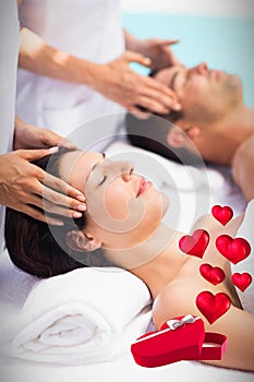 Composite image of couple in spa and hearts flying from box 3d