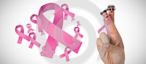 Composite image of cropped hand of woman with pnik breast cancer awareness ribbon photo