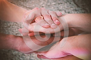 Composite image of cropped image of people forming hands stack