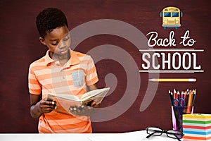 Composite image of cute boy reading book in library