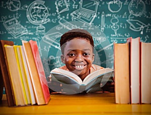 Composite image of cute boy reading book in library