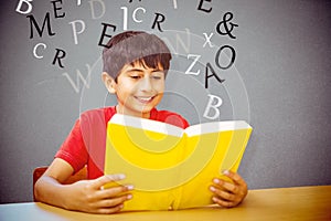 Composite image of cute boy reading book in library