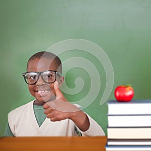 Composite image of cute pupil showing thumbs up