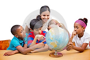 Composite image of cute pupils and teacher looking at globe in library