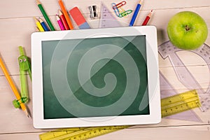 Composite image of digital tablet on students desk