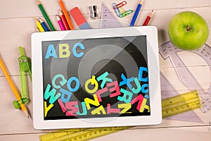 Composite image of digital tablet on students desk