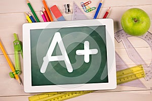 Composite image of digital tablet on students desk