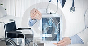 Composite image of doctor showing a digital tablet
