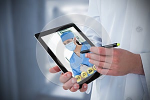 Composite image of doctor using digital tablet