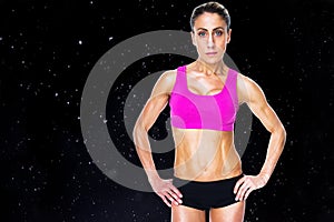 Composite image of female bodybuilder posing with hands on hips looking at camera