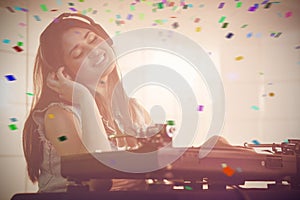 Composite image of female dj listening to headphone while playing music