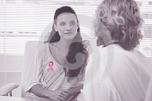 Composite image of female patient listening to doctor with concentration in medical office