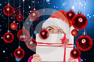 Composite image of festive blonde holding christmas gift