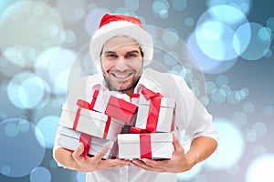 Composite image of festive man holding christmas gifts photo