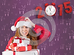 Composite image of festive stressed redhead holding gifts