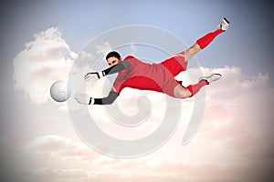 Composite image of fit goal keeper jumping up