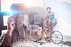 Composite image of fit man cycling on rocky terrain