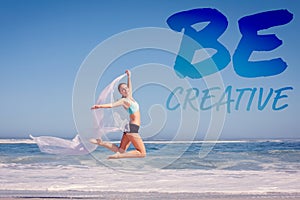 A Composite image of fit woman jumping gracefully on the beach with scarf
