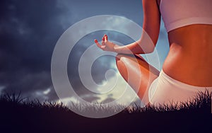 Composite image of fit woman sitting in lotus pose