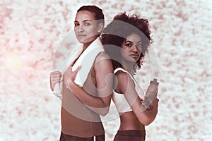 Composite image of fit women standing with waterbottle and towel