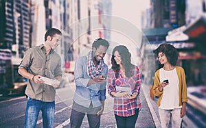 Composite image of four stylish friends looking at tablet and holding phones