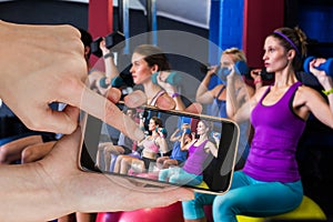 Composite image of friends holding dumbbells while sitting on fitness ball