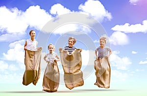 Composite image of friends playing sack race