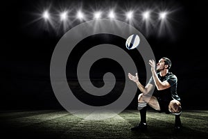 Composite image of full length of rugby player catching the ball